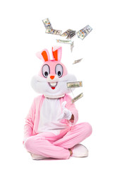 Easter bunny rabbit throws up dollars, celebrates easter. Rich lucky man person under rain of hundred dollar bills