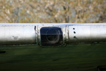 Glass opening on wing of old Douglas Dakota DC-3 WWII plane placed in field at exhibit on warm sunny spring day