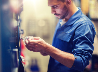 car service, repair, maintenance and people concept - auto mechanic man or smith at workshop or warehouse