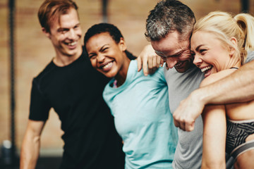 Diverse friends laughing together while standing in a gym
