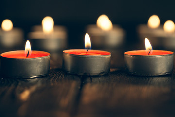 candles burning in darkness over black background. commemoration concept.