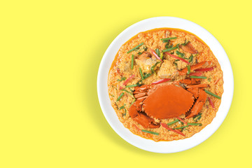  Fried crabs with curry powder is Thai food cuisine in Thailand isolated on white dish top view on yellow table.