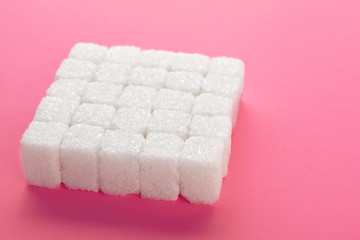 Cubes of sugar on a pink background. Empty space for copying text