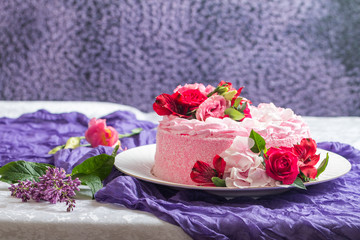 Pink cake with natural beautiful flowers as a decoration