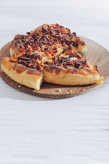 Homemade pizza on white wooden background on kitchen board