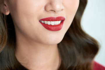 Fototapeta premium Sexy sensual red lips with mouth open. Beautiful lips Makeup. Close up red lips of asian girl.