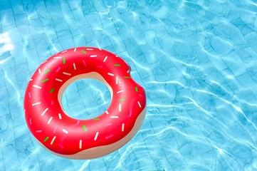 Donut shape, floating rubber ring in the swimming pool - obrazy, fototapety, plakaty