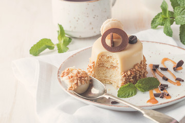 Caramel coffee cake in a glaze with nuts on plate over white background