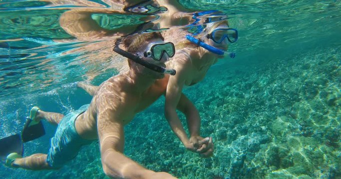 POV of young attractive couple snorkeling together