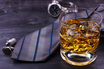Male concept for father's day. Tie, watches, cufflinks and a glass of whiskey with ice