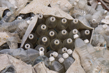 soaking cardboard boxes filled with dirty plastic bottles