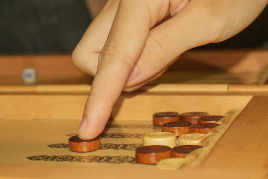 backgammon game. The player's hand moves the chip, closeup