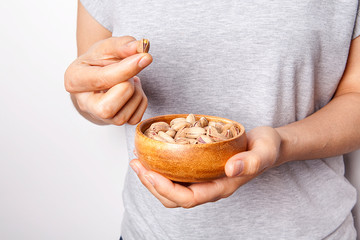 Woman's in hand  pistachio in a bowls. Healthy food and snack.