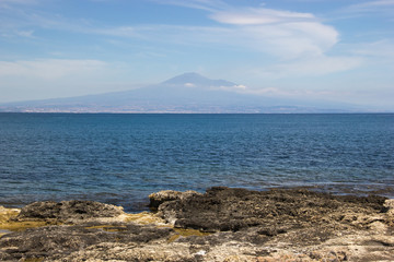 Brucoli view of sea from coast, the distant Etna volcano and the blue sea and sky