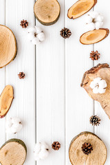 Tree stumps, immortelle and cones frame for presentation background top view copy space