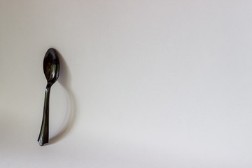 Black spoon on a white background. Minimal concept. Abstract.