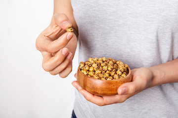 Woman's in hand roasted and dry chickpeas in a bowls.