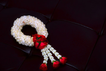 Jasmine and rose garland on leather cover floor background