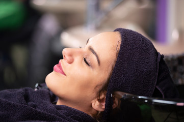 young woman in hairdresser salon, towel on head