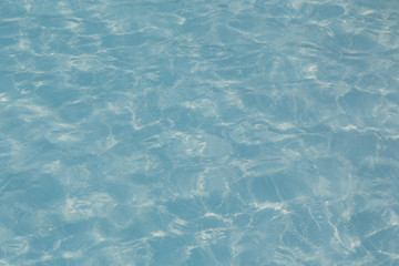 Blue pool water with sun reflections