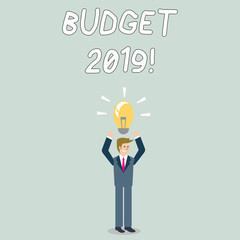 Word writing text Budget 2019. Business photo showcasing estimate of income and expenditure for current year Businessman Standing Raising Arms Upward with Lighted Bulb Icon on his Head