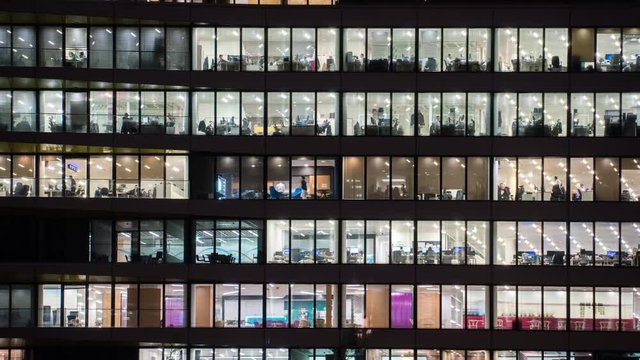 Timelapse at evening of a modern office building with glass windows