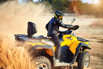 Racing powerful quad bike on the difficult sand in the summer. © Bondariev Volodymyr.