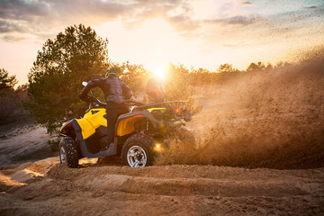 Racing powerful quad bike on the difficult sand in the summer.
