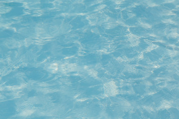 Blue pool water with sun reflections