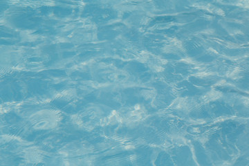 Blue pool water with sun reflections