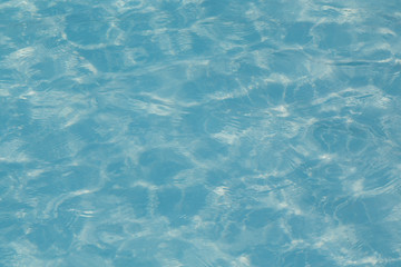 Blue pool water with sun reflections