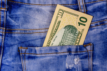 American ten dollar banknotes in a pocket of blue jeans