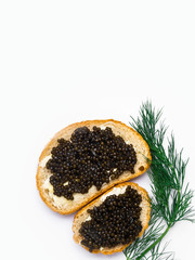Two slices of baguette with butter and black caviar isolated on white background. Luxurious delicacy appetizer.