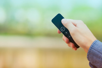 Hand holding remote control. Blured background. Remote control devices concept. Space for a text....