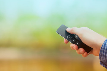 Hand holding remote control. Blured background. Remote control devices concept. Space for a text....