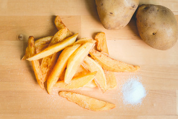 Homemade French Fries and Salt  on wooden table.
