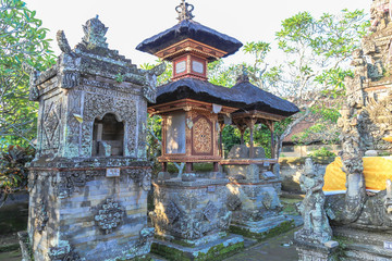 Shrine made of stone and gold gild is within an ancient Balinese temple.