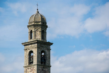 Fototapeta na wymiar Ancient bell tower on medieval church against blue sky
