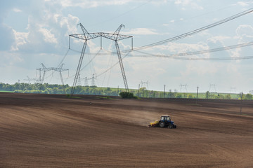Spring fields with bloom rape and power lines.
