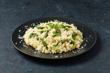 Classic Italian risotto with asparagus. Front view. Darkblue background.