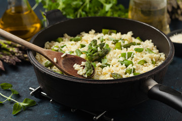 Classic Italian risotto with asparagus. Front view. Darkblue background.