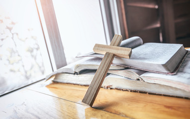 Close up cross on books or bible on wooden table. christian concept.