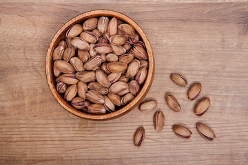 Pistachio  in a bowls on wooden table. Healthy food and snack.