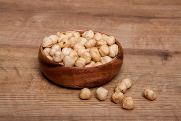 Hazelnut in a bowls on wooden table. Healthy food and snack.