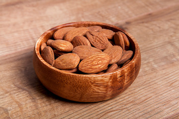 Almond in a bowls on wooden table. Healthy food and snack.