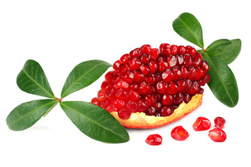 piece of pomegranate with seeds and green leaves isolated on a white background.