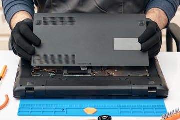 Engineer dismantles the details of a broken laptop for repair