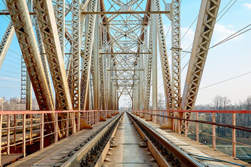 Reliable railway bridge, against the backdrop of beautiful nature and blue sky. Looking through the bridge. Backgound
