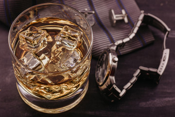 Male concept for father's day. Tie, watches, cufflinks and a glass of whiskey with ice