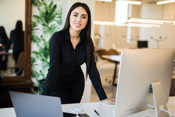 Attractive young business woman working on laptop at office. Business people.